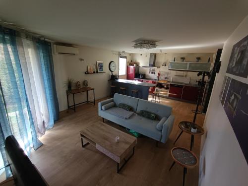 un salon avec un canapé bleu et une table dans l'établissement Spacieux T3 cosy avec clim et terrasse à Toulouse, à Toulouse