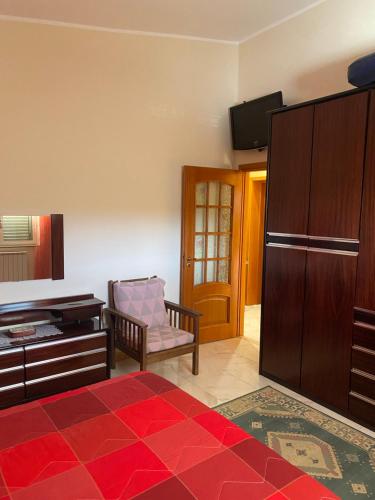 a bedroom with a bed and a tv and a chair at Villa Rosa in Canicattini Bagni
