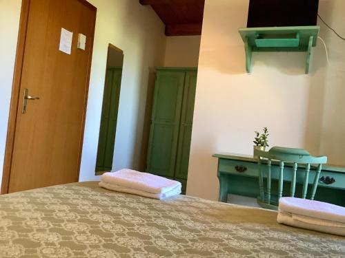 a bedroom with a bed and a desk and a chair at Hotel Golfo del Leone in Portixeddu