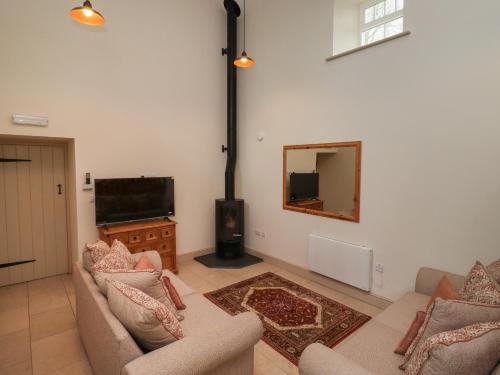 a living room with two couches and a flat screen tv at Cragg Lodge in Hexham