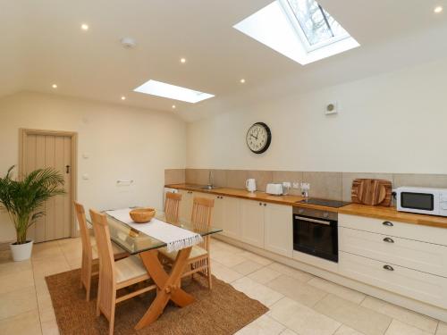 a kitchen with a table and chairs and a clock at Cragg Lodge in Hexham