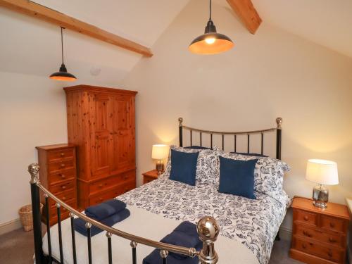 a bedroom with a bed with blue pillows at Cragg Lodge in Hexham