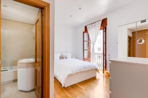 een slaapkamer met een bed en een badkamer bij Serrano & Claudio Coello: Lujo, Luz y Elegancia in Madrid