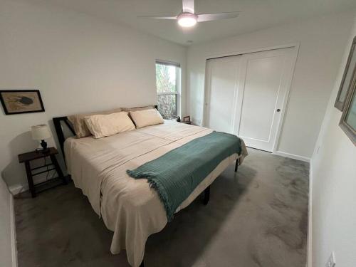 a bedroom with a large bed in a white room at The Butterfly House - with sauna in Sanford