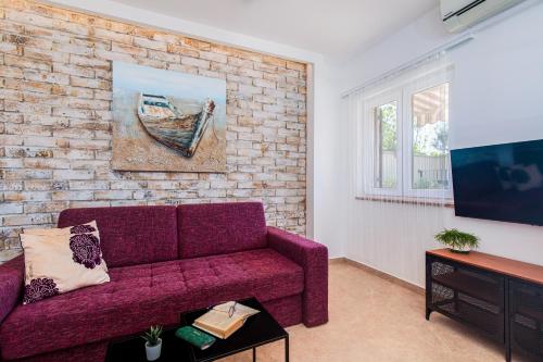 a living room with a purple couch and a brick wall at Pipo in Rijeka