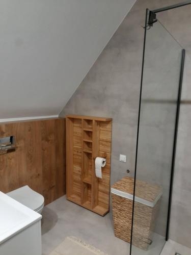 a attic bathroom with a toilet and a shower at Apartament Kapłonówka in Bańska