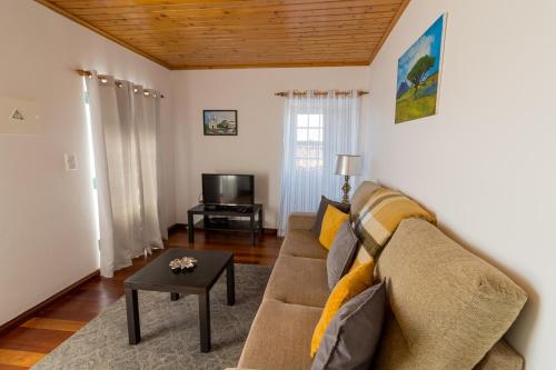 a living room with a couch and a table at Casa do Furtadinho in Madalena