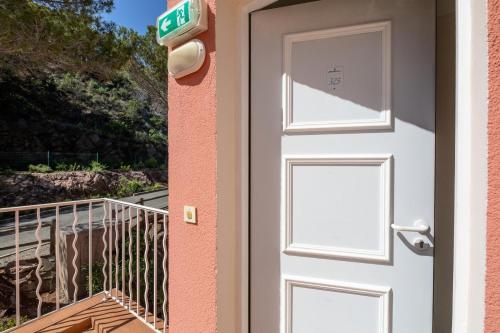 una puerta a una casa con balcón en Résidence le Hameau de Cap Esterel - maeva Home - Appartement 2 Pièces 5 Pe 33, en Saint-Raphaël
