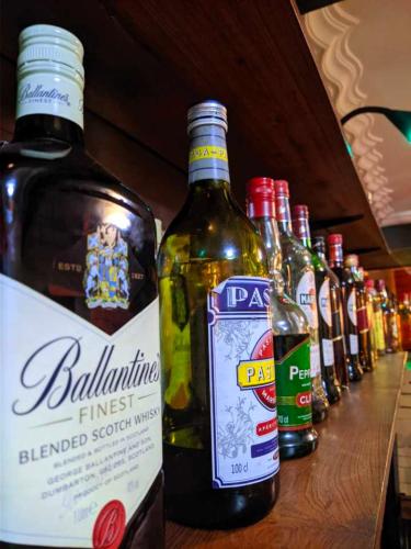 a row of bottles of alcohol sitting on a counter at L'anis Etoilé - Hôtel Restaurant in Antsirabe