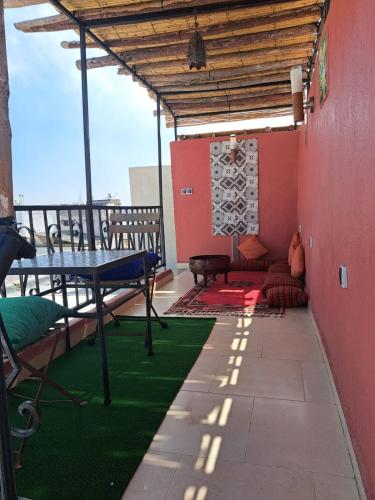 a patio with a table and a couch on a balcony at Dar Si hmed in Rabat