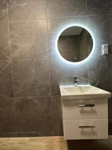 a bathroom with a sink and a mirror at Dom wakacyjny Welle Dziwnów in Dziwnów