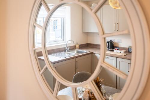 a kitchen with a sink and a mirror at Poppy House - Coastal Getaway 2 Bedroom in Scalby in Scalby