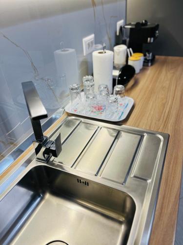 a kitchen with a sink and a counter with glasses at ALBI’S Apartment in Tirana