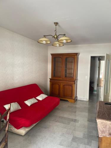 a bedroom with a red bed and a wooden cabinet at Oasis urbaine appartement 2 pièce in Nice