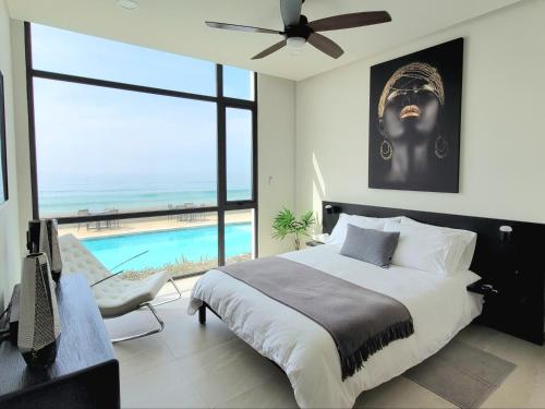 a bedroom with a large bed and a swimming pool at Luxury Beachfront Condo in Rosarito Pool & Jacuzzi in Rosarito