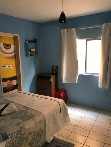 a blue bedroom with a bed and a window at Traveler gu's room AP compartilhado in Fortaleza