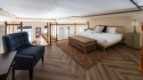 een slaapkamer met een bed en een blauwe stoel bij Mason's View - Cincy Hilltop Apartment in Cincinnati