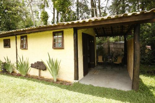 a small yellow house with a patio in a yard at Apoena Chales da Ilha in São Francisco Xavier