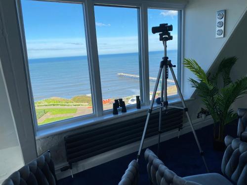 a camera on a tripod in a room with a view of the ocean at Blue Ocean Seaview Penthouse Perfectly Saltburn in Saltburn-by-the-Sea