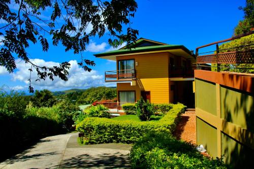 une maison jaune avec un balcon sur le côté. dans l'établissement Hotel Ficus - Monteverde, à Monteverde Costa Rica