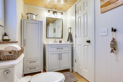 uma casa de banho com um WC, um lavatório e um espelho. em Updated Wellston Cabin Near Boating and Fishing! em Irons