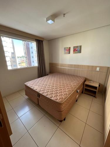 a bedroom with a large bed and a window at Casa da madeira - ate 5 pessoas - Centro in Caldas Novas