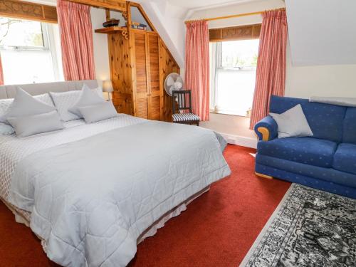 sypialnia z łóżkiem i niebieską kanapą w obiekcie The Nook w mieście Llanrwst