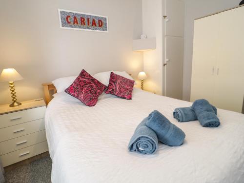um quarto com uma cama com toalhas azuis em Oriel Cottage em Conwy