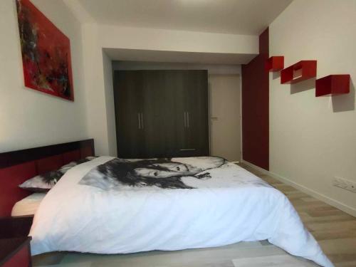 - une chambre avec un grand lit orné d'une peinture murale dans l'établissement Appartement en centre ville, à Villedieu-les-Poêles