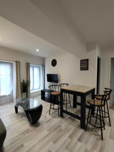 - un salon avec une table et des chaises dans l'établissement Appartement en centre ville, à Villedieu-les-Poêles