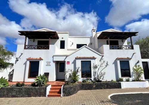 a white house with black windows at Casa-la-Costa in La Costa