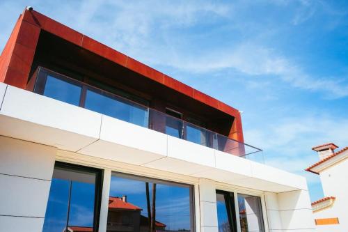 a red and white building with glass windows at Marlages House in Lavra