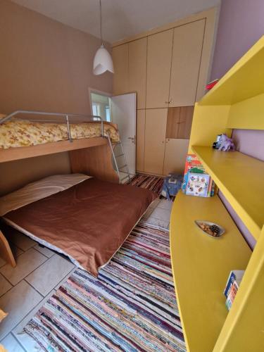 VromopoúsiにあるPerigiali Seasideの二段ベッドとラグ付きの小さな客室です。