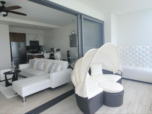a living room with white furniture and a white couch at Luxury Beachfront Condo in Rosarito with Pool & Jacuzzi in Rosarito