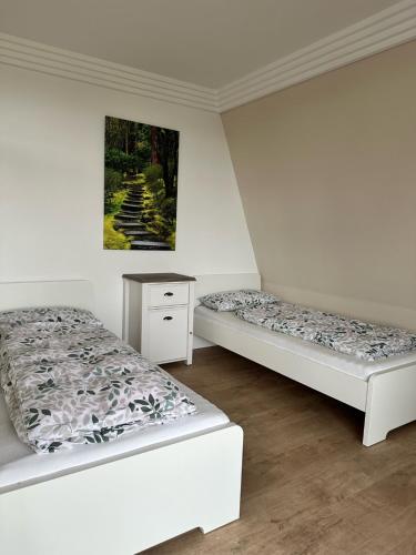 two beds in a room with a picture on the wall at Top Monteurwohnung Stuhr-Brinkum mit perfekter Anbindung in Stuhr