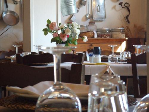 - une table avec un verre de vin et un vase de fleurs dans l'établissement Agriturismo Il Cucco, à Altedo