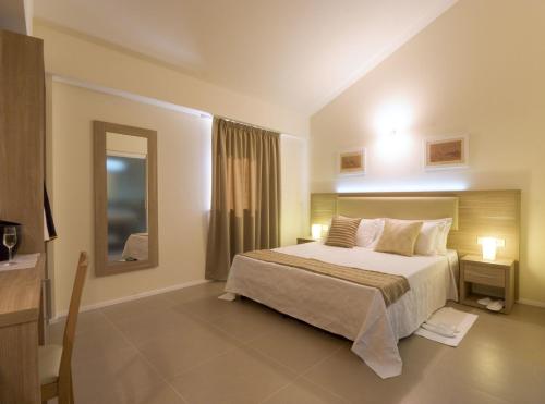 a bedroom with a large bed and a mirror at Palazzo Ruschioni Boutique Hotel in Camerano
