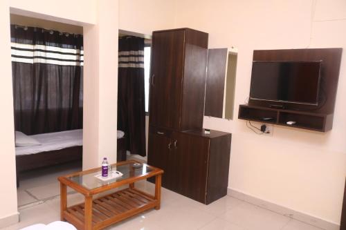 sala de estar con TV y mesa de centro en Hotel Ashirwad, en Jabalpur
