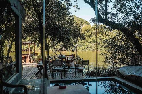 a patio with a table and chairs next to a pool at Casanova Residence - Barra da Tijuca na Ilha da Gigoia in Rio de Janeiro