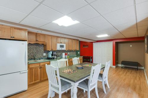 a kitchen with a table and chairs and a white refrigerator at Rock Island Home with Private Yard and Fire Pit Table! in Rock Island