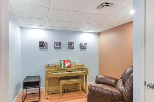 a room with a piano and a leather chair at Rock Island Home with Private Yard and Fire Pit Table! in Rock Island