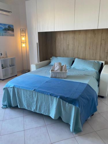 a large bed with blue sheets and two baskets on it at Casa di Jack I.U.N. R6217 in Quartu SantʼElena