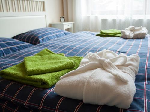two beds with green and white towels on them at Hostinec & Vitální svět Raduňka in Opava
