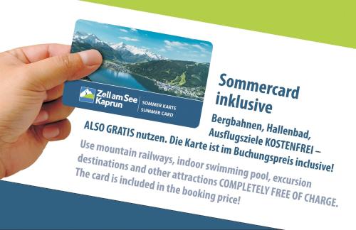 une main tenant un billet pour une chaîne de montagnes dans l'établissement Chalet Panoramablick Zell am See, à Zell am See