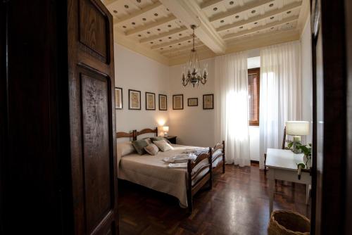 um quarto com uma cama e um lustre em Villa Allegrini em Segni