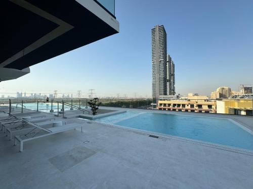 a swimming pool on the roof of a building at ASHRI HH, Luxurious Apt in JVC in Dubai