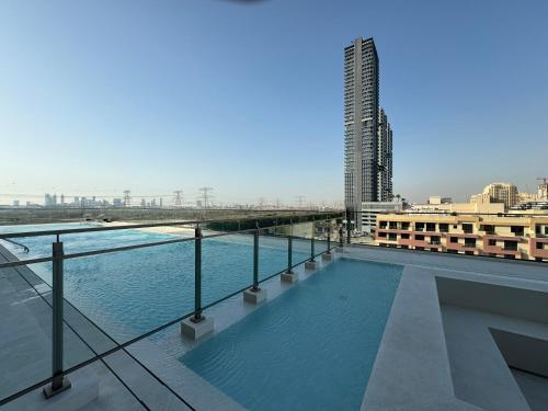 a swimming pool on the roof of a building at ASHRI HH, Luxurious Apt in JVC in Dubai