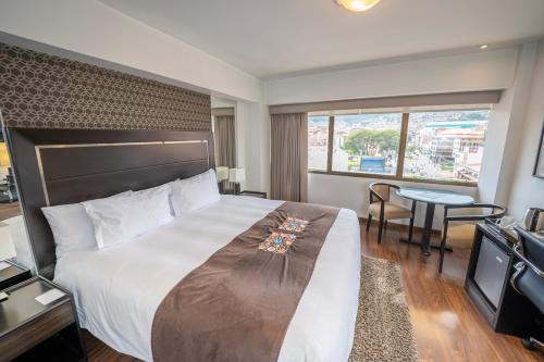 una habitación de hotel con una cama grande y una mesa en Hotel Jose Antonio Cusco, en Cusco