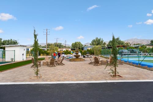 a patio with chairs and a fountain next to a pool at RV41-LOT ONLY- Paradise RV park in Desert Hot Springs