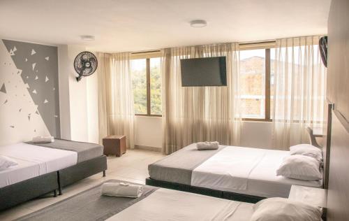 1 dormitorio con 2 camas y TV de pantalla plana en Hotel Inter del Café, en Pereira